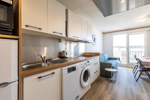 a kitchen with a sink and a washing machine at 2 pièces face océan, Lacanau in Lacanau