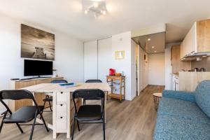 a living room and kitchen with a table and chairs at 2 pièces face océan, Lacanau in Lacanau +12 photos
