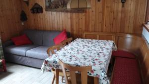 a kitchen with a table and a couch in a room at Luminoso appartamento centrale in Ponte di Legno +18 photos