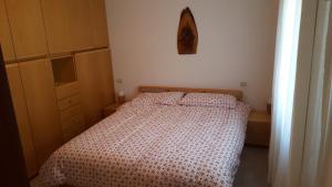 a bedroom with a bed with a red and white comforter at Luminoso appartamento centrale in Ponte di Legno