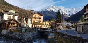a bridge over a river in a town with mountains at Luminoso appartamento centrale in Ponte di Legno