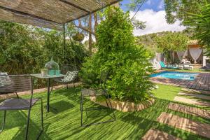 a backyard with a table and chairs and a tree at Es Clos in El Port de la Selva
