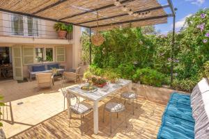 a patio with a table and chairs and a pergola at Es Clos in El Port de la Selva