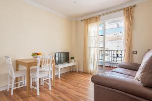 a living room with a couch and a table and a television at House Sun Beach 2 in Vejer de la Frontera