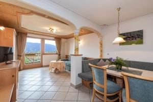 a living room with a couch and a table with chairs at Residence Diana Apartment 102 in Terento