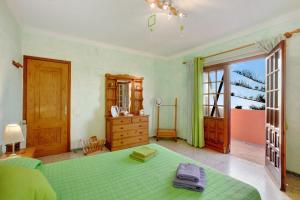 a bedroom with a green bed and a window at Villa Petite Paradise in Las Lagunas +25 photos