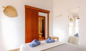 a bedroom with a bed with blue towels on it at Villa Estrellas 2 in Cala en Bosc