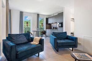 a living room with two blue chairs and a kitchen at Egge Resort 7b mit Whirpool u Sauna in Altenbeken