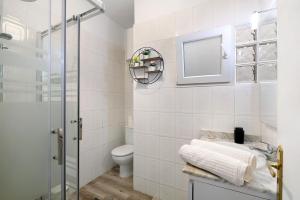 a bathroom with a toilet and a sink and a mirror at Piso Leon y Castillo B in Arrecife +12 photos