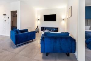 a living room with two blue chairs and a tv at Egge Resort 7b mit Whirpool u Sauna in Altenbeken