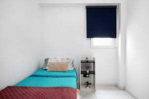 a small bedroom with a bed and a window at Piso Leon y Castillo B in Arrecife