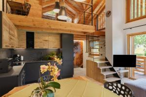 a kitchen and living room with wooden ceilings and a table at Mas de la Tata in Rabbi
