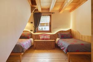 two beds in a room with a window at Mas de la Tata in Rabbi