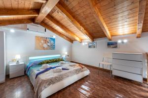 a bedroom with a large bed and wooden ceilings at Casa Ornella in Nebida