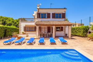 a villa with a swimming pool in front of a house at Villa Isabel in Campos
