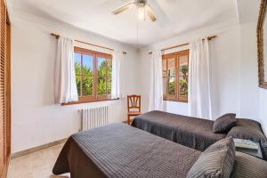 two beds in a room with two windows at Villa Isabel in Campos +17 photos