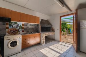 a kitchen with a stove and a washer and dryer at Casa Lilliu in Villacidro