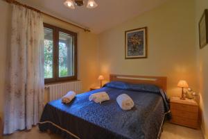 a bedroom with a blue bed with two towels on it at Casa Lilliu in Villacidro