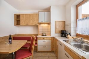 a kitchen with a table and a sink and a counter at Wollbach - Gruberhof in San Giacomo
