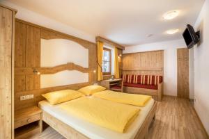 a bedroom with a large bed with yellow sheets at Wollbach - Gruberhof in San Giacomo