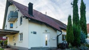 a white house with a red roof at Ferienwohnung Arenda in Munzingen