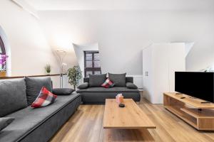 a living room with a couch and a tv at Ferienwohnung Fernblick in Pottenstein
