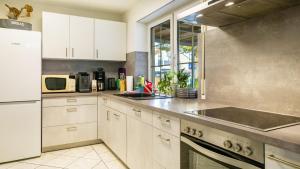 a kitchen with white cabinets and a sink at Ferienwohnung Arenda in Munzingen