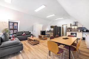 a living room with a table and a kitchen at Ferienwohnung Fernblick in Pottenstein