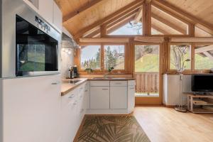 a kitchen with white cabinets and a large window at Ferienwohnung Thymian Thalerhof in Ponte Nova