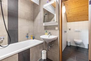 a bathroom with a sink and a tub and a toilet at Ferienwohnung Fernblick in Pottenstein +18 photos