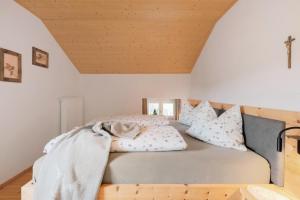 a bed in a room with a cross on the ceiling at Ferienwohnung Thymian Thalerhof in Ponte Nova