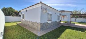 a white house with a stone wall at Chalet Tu Limonero in Chiclana de la Frontera