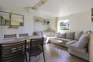 a living room with a couch and a table at Mobilhome 373 in Lattes