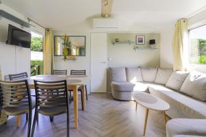 a living room with a couch and a table at Mobilhome 373 in Lattes