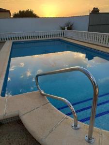 a swimming pool with a hand rail in the water at Chalet Tu Limonero in Chiclana de la Frontera