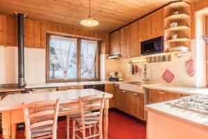 a kitchen with wooden cabinets and a table and chairs at The Lodge Monte Bondone in Vason