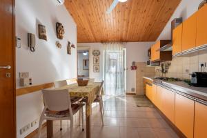 a kitchen with a wooden ceiling and a table and chairs at La Casetta Della Rocca Cefalù in Cefalù