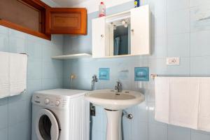 a bathroom with a washing machine and a sink at La Casetta Della Rocca Cefalù in Cefalù
