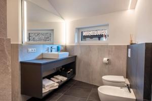 a bathroom with a sink and a toilet at Luisl Hof - Apartment Pomum in Cornaiano +24 photos