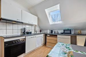 a kitchen with white cabinets and a black stove top oven at Haus Elseaue in Bünde