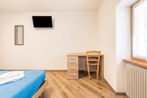 a bedroom with a desk and a bed and a chair at Appartamento Glolo 2 in San Lorenzo in Banale
