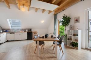 a kitchen and dining room with a wooden table and chairs at Ferienwohnung Panoramablick in Leipheim