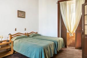 a bedroom with a bed with a blue blanket and a window at Casa Pollo Buen Lugar in Casablanca