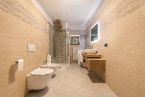 a bathroom with a toilet and a sink and a shower at Appartamento Glolo 2 in San Lorenzo in Banale +18 photos