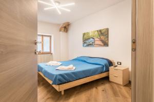 a bedroom with a bed with a blue comforter at Appartamento Glolo 2 in San Lorenzo in Banale