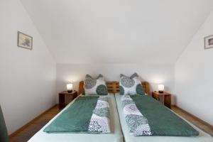 a bedroom with two beds with green and white pillows at Ferienwohnung Panoramablick in Leipheim