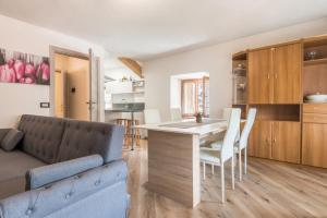a kitchen and living room with a table and chairs at Appartamento Glolo 2 in San Lorenzo in Banale