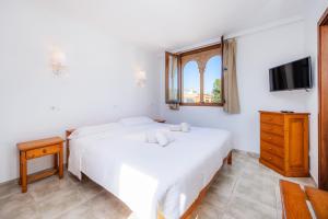 a bedroom with two beds and a tv at Sa Torre iii in Canyamel +27 photos