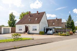 a white house with a car parked in the driveway at Haus Elseaue in Bünde