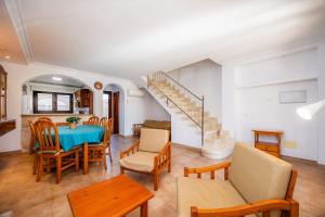 a living room with a table and chairs and a staircase at Sa Torre iii in Canyamel